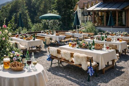Gedeckte Tische im Rahmen eines Dorffests oder einer Hochzeit auf dem Dorfplatz des Steinschaler Dörfl in Frankenfels, dahinter atemberaubender Ausblick in die Kulturlandschaft des Dirndltals