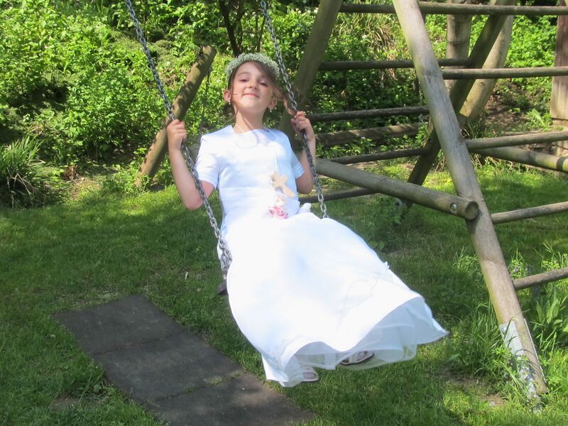 Datei:SH Erstkommunionkind Schaukel.jpg