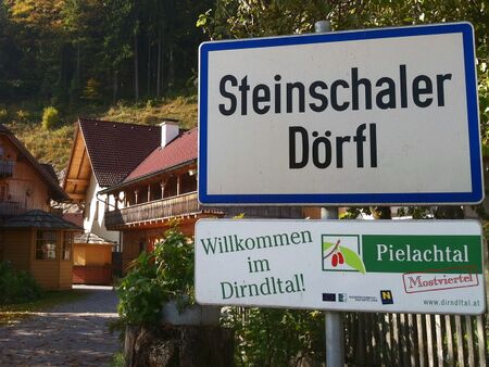 Ortsschild und Dorfplatz im Herbst